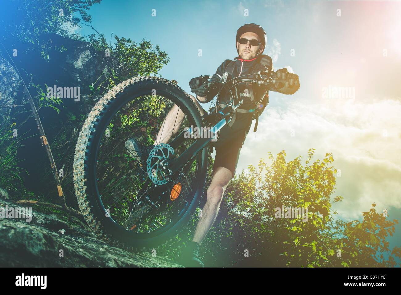 Extreme Bike Ride Sport. Kaukasische Biker auf seinem Mountainbike auf den Felsen. Stockfoto
