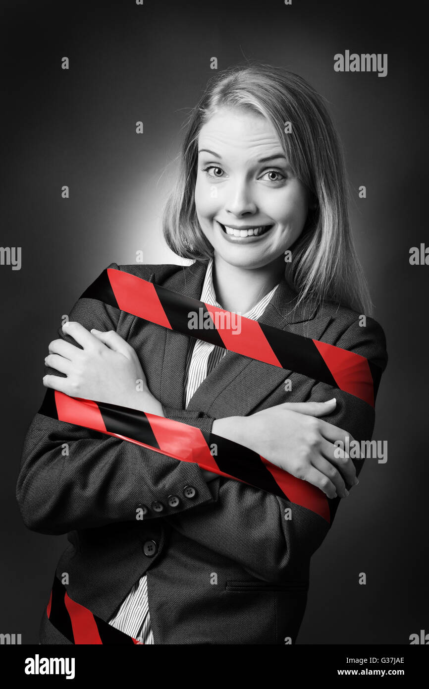 Business-Modell ist mit einem schwarzen und roten Streifen Klebeband umwickelt ihr gefesselt. Stockfoto