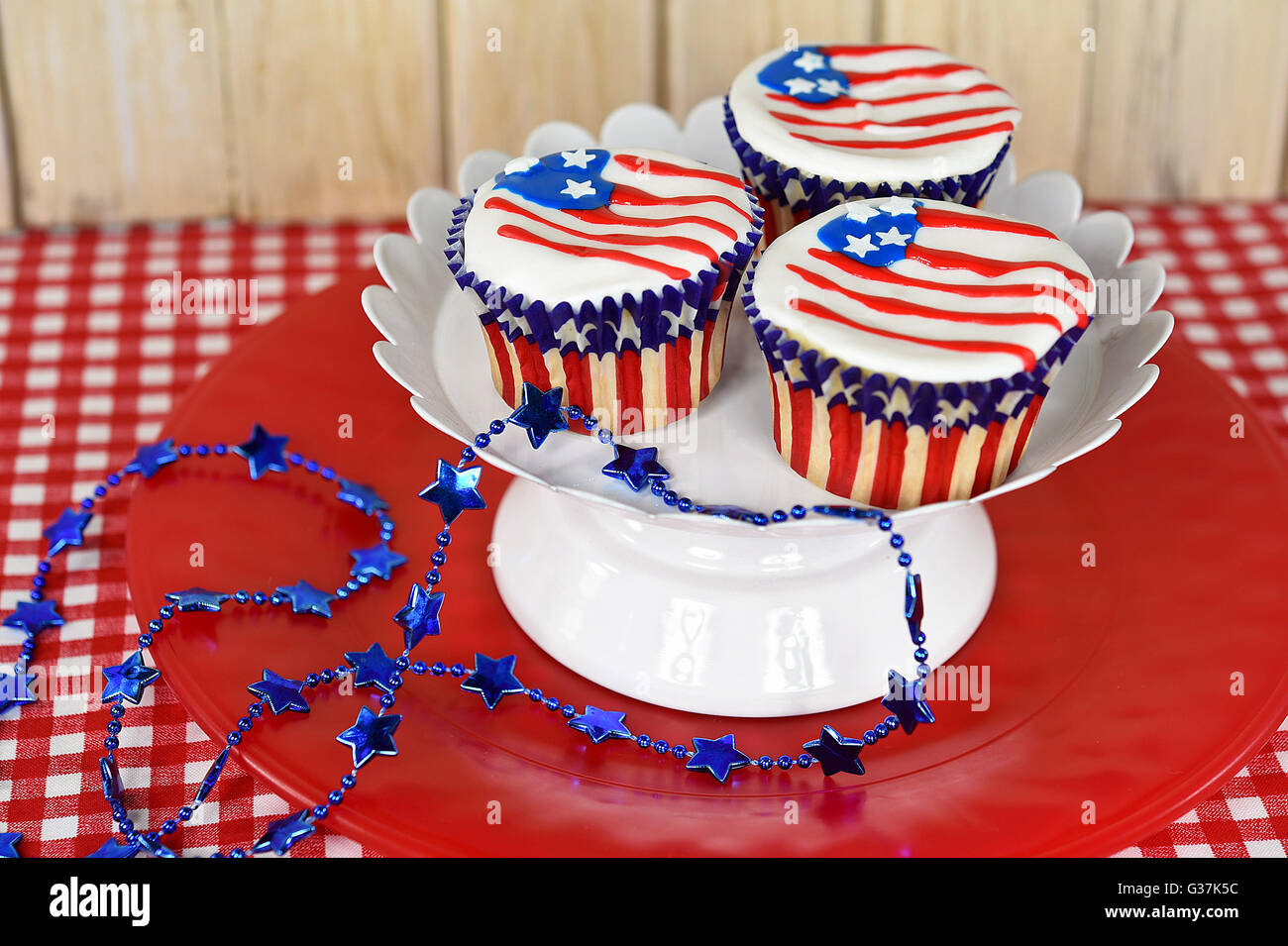 Zuckerguss auf patriotische Cupcakes mit blauen Sterne Halskette Deko Flagge. Stockfoto