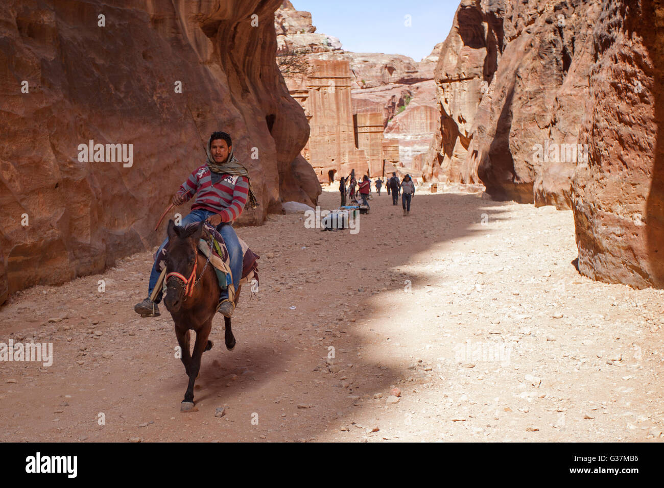 Eine junge Beduine, die auf einem Esel in Petra reitet, auch bekannt als die „Rosenstadt“, Jordanien, Naher Osten. Stockfoto