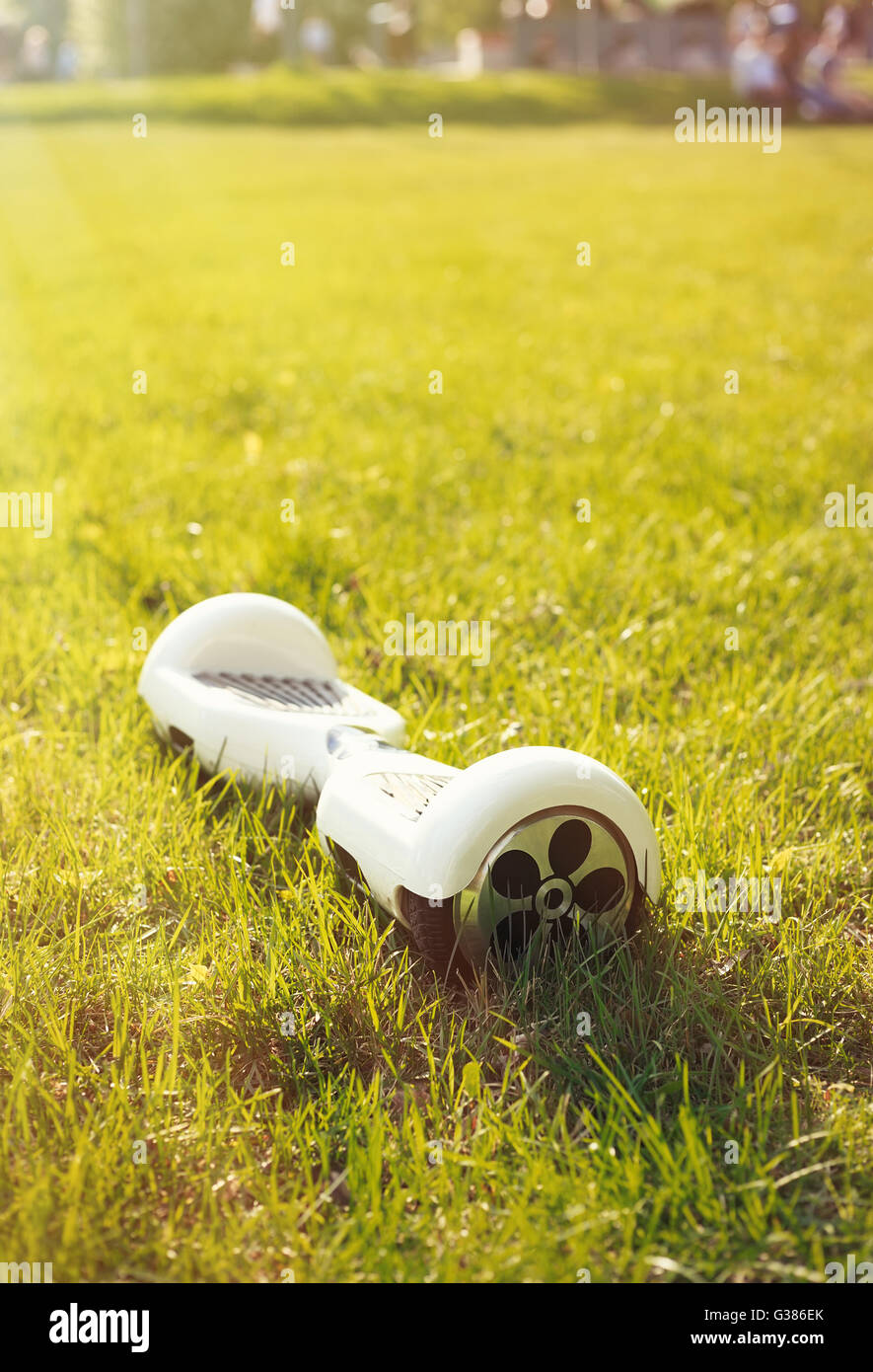 Weiße Mini schweben Board Elektroroller auf dem grünen Rasen im Park. Eco-Stadtverkehr im Akkubetrieb, produzieren keine Luftverschmutzung, Atmosphäre Stockfoto