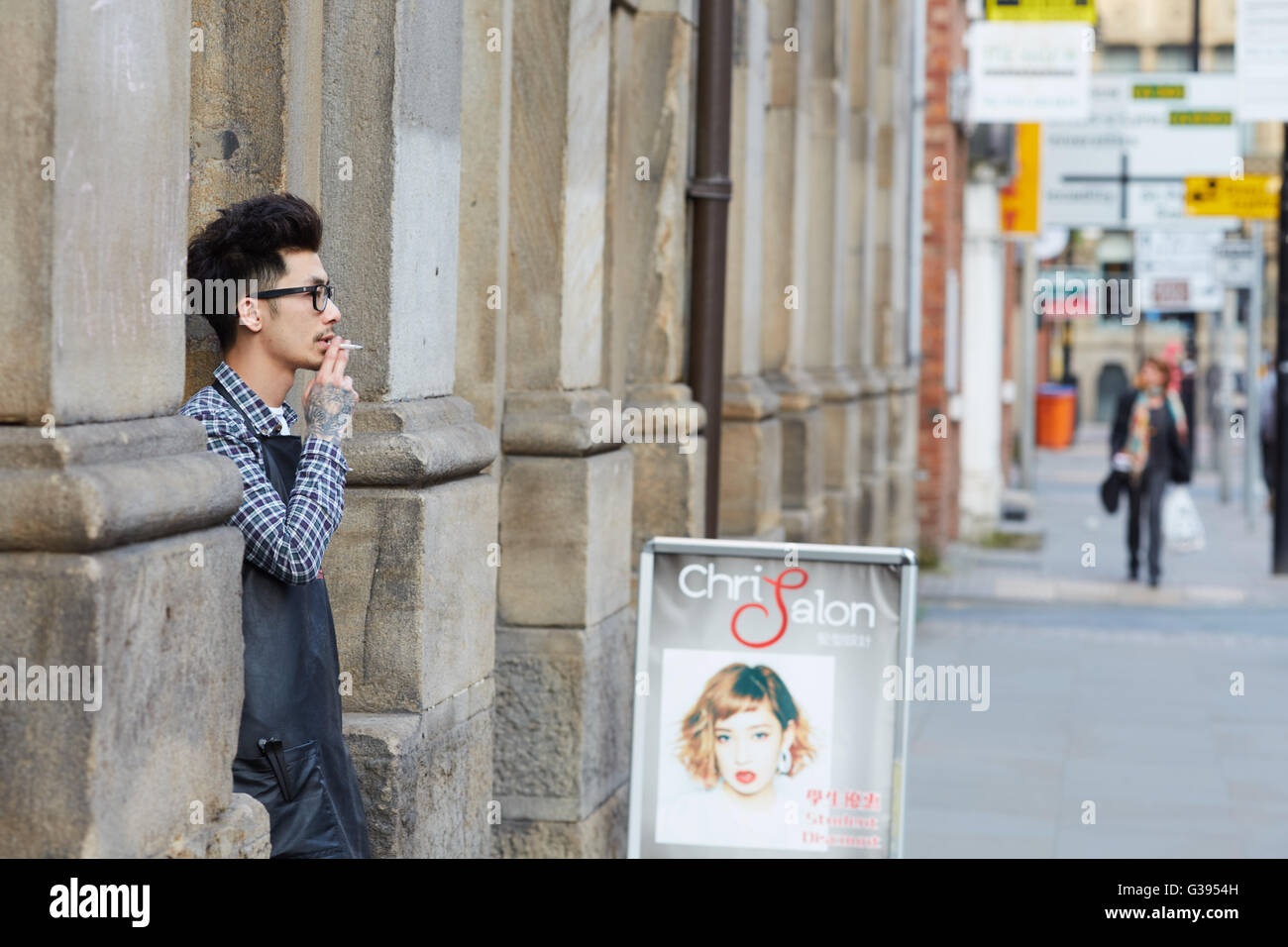 mit Blume shop Straße Manchester Princess Street Arbeiter Pausenzeit Rauchen auf Rest ausruhen Friseur asiatische chinesische wal Stockfoto