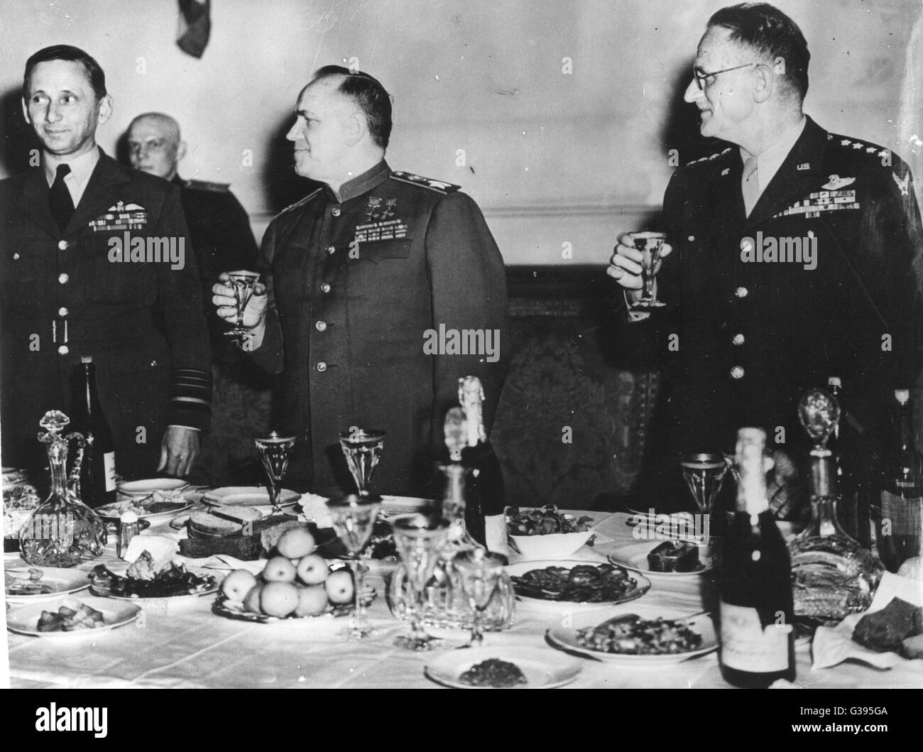 (L-R) Air Chief Marshal Sir Arthur Tedder, stellvertretender Supreme Commander Allied Forces, fangen Sie Marschall Georgy K. Zhukov, Stellvertretender Oberbefehlshaber der sowjetischen Streitkräfte und General Carl A. Spaatz, USAAF, toasten, die zur Unterzeichnung der bedingungslosen Kapitulation. Stockfoto