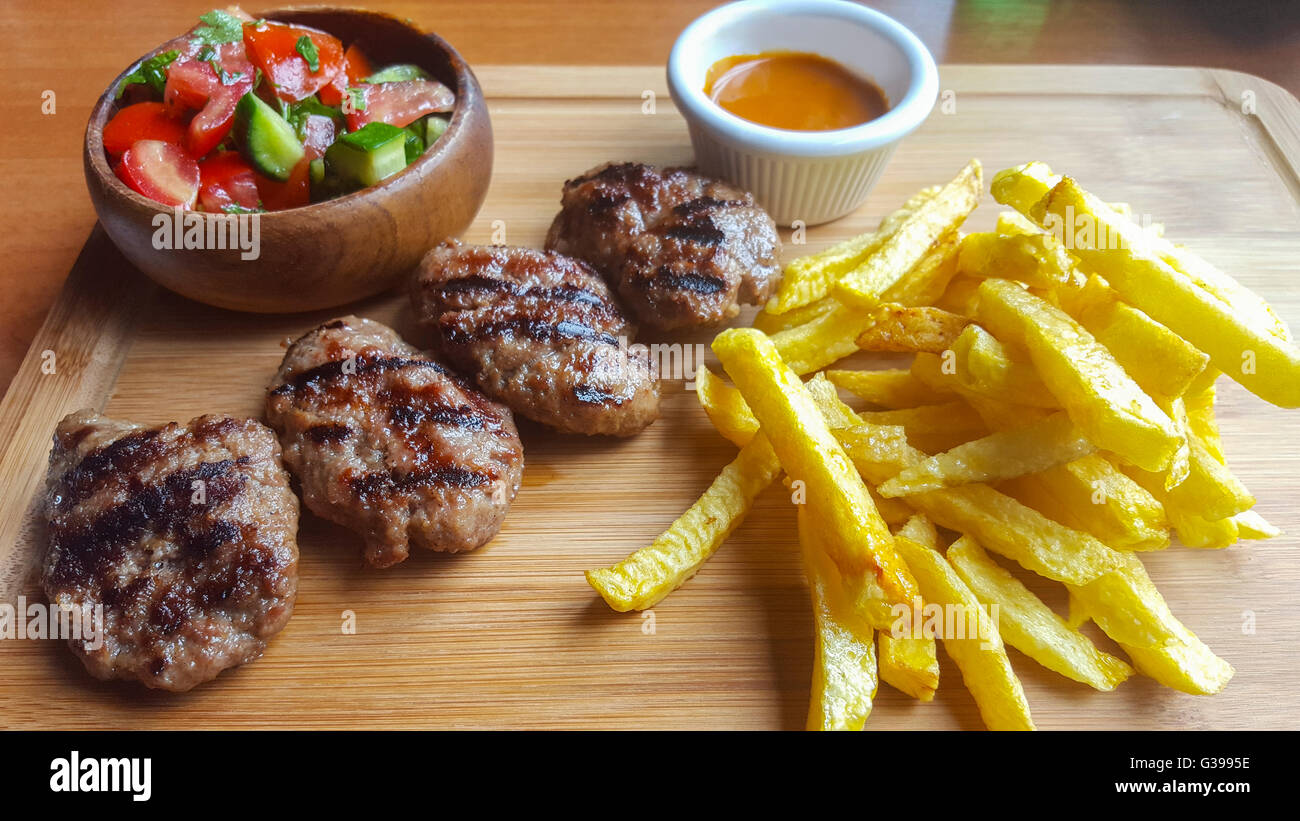 Türkische Frikadellen mit Gemüse und Pommes frites serviert. Stockfoto