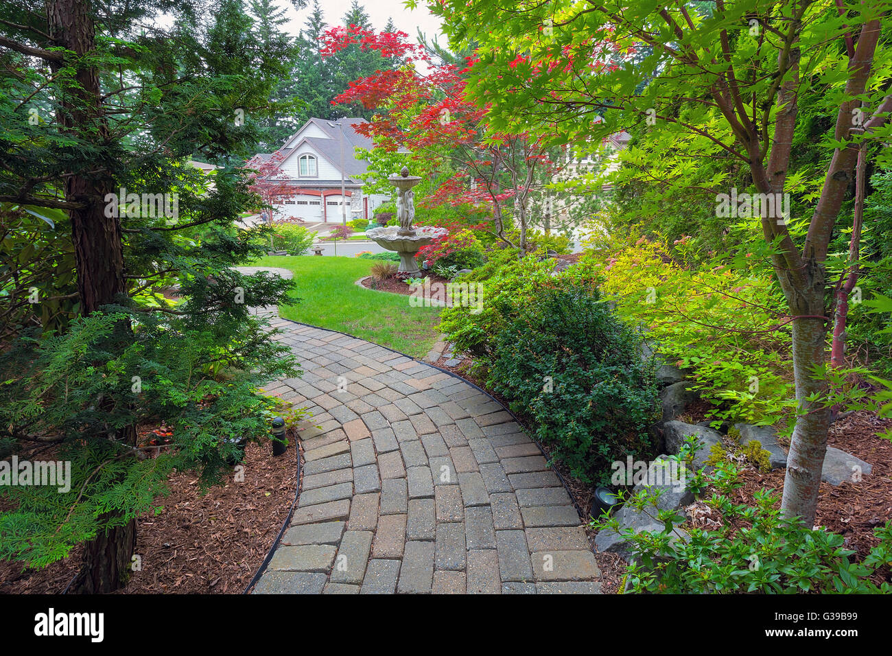 Garten Backstein Fertiger Weg Im Vorgarten Mit Springbrunnen Pflanzen Straucher Immergrune Und Laubabwerfende Baume Landschaftsbau Stockfotografie Alamy