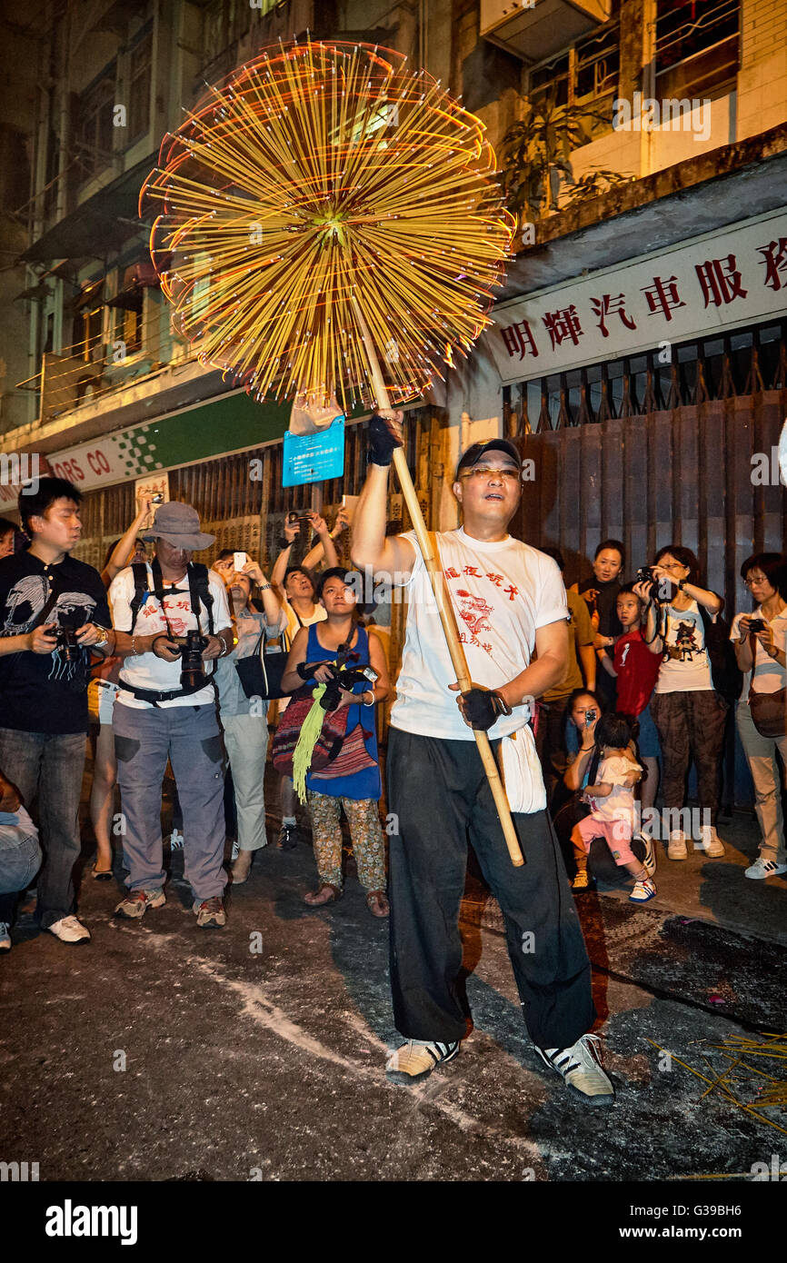 Ein Träger hisst empor die zitternde und feurigen Weihrauch beladenen Leiter des inzwischen berühmten Fire Dragon Dance in Tai Hang, Hong Kong. Stockfoto