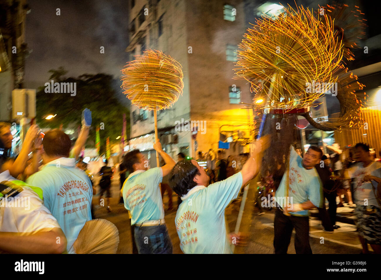 Ein Träger hisst empor die zitternde und feurigen Weihrauch beladenen Leiter des inzwischen berühmten Fire Dragon Dance in Tai Hang, Hong Kong. Stockfoto