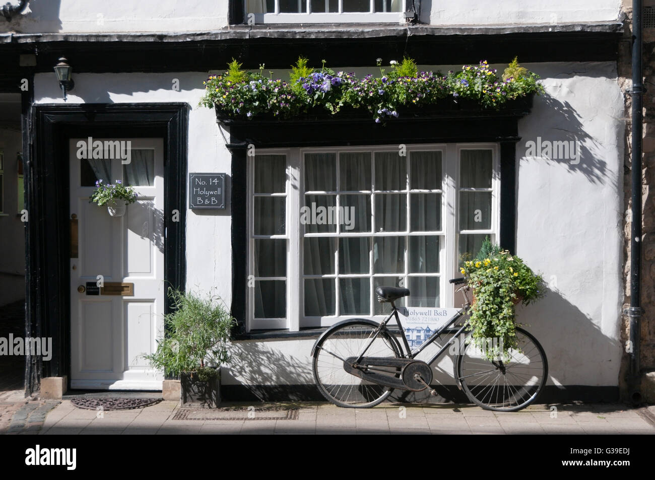 Flowerboxes und Fahrrad vor Oxford Unterkunft mit kleinen Fensterscheiben. Stockfoto