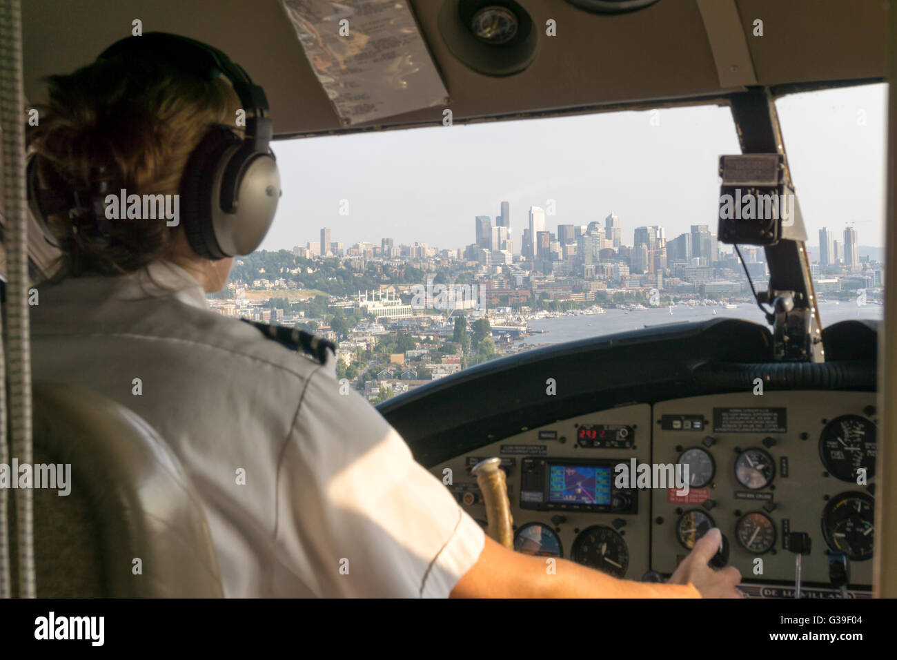 Pilotin von Wasserflugzeug landen am Lake Union, Seattle mit der Skyline der Stadt, gesehen durch die Cockpit-Fenster herein. Stockfoto