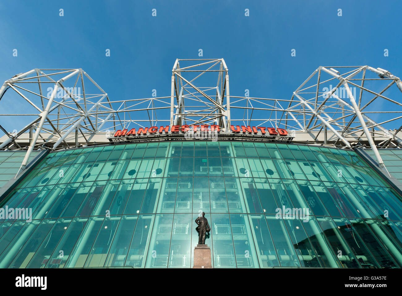 Old Trafford, das Stadion von Manchester United Football Club, mit der Sir Matt Busby-Statue an einem sonnigen Tag (nur zur redaktionellen Verwendung) Stockfoto