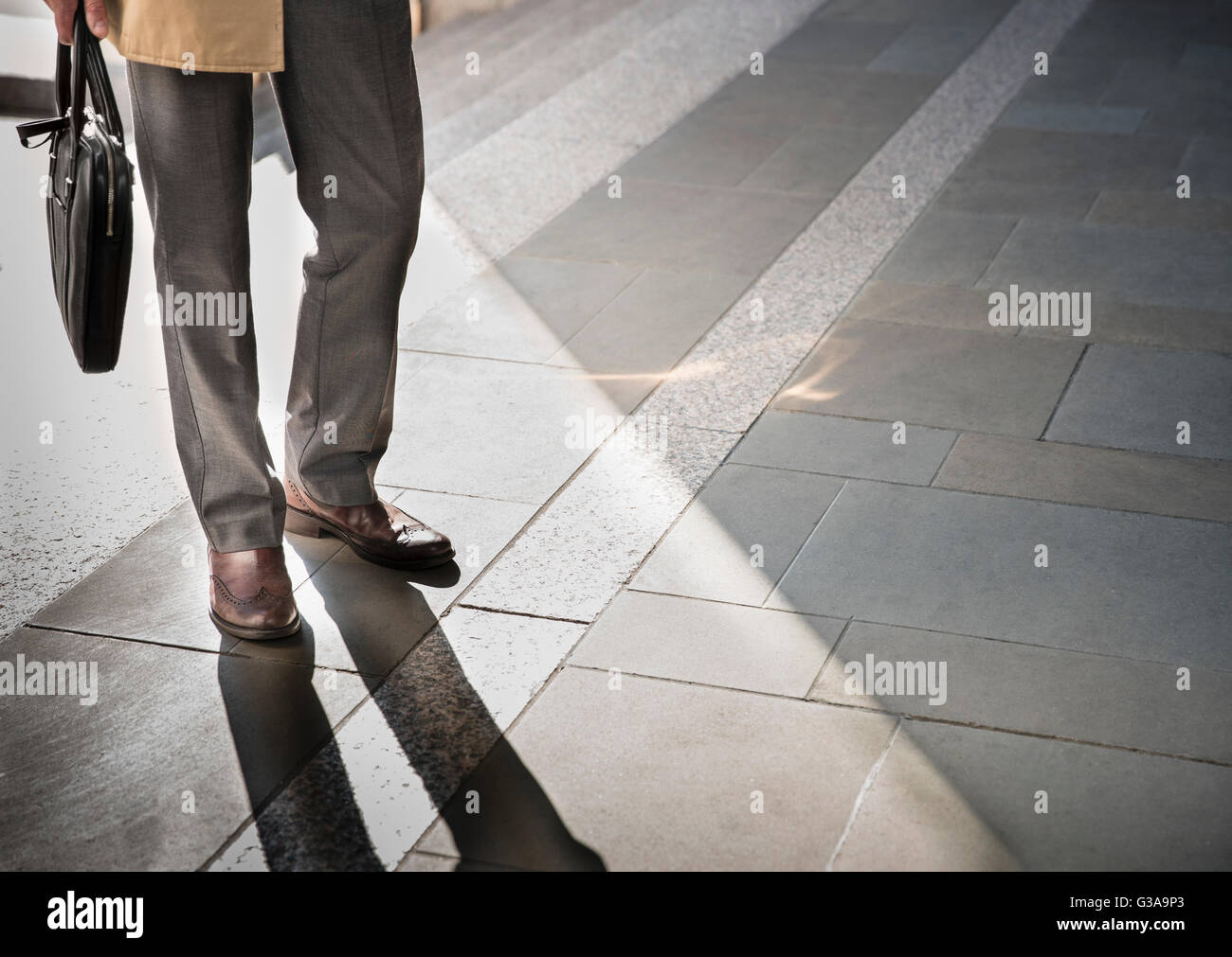 Corporate Geschäftsmann stehend auf sonnigen Pflaster Stockfoto