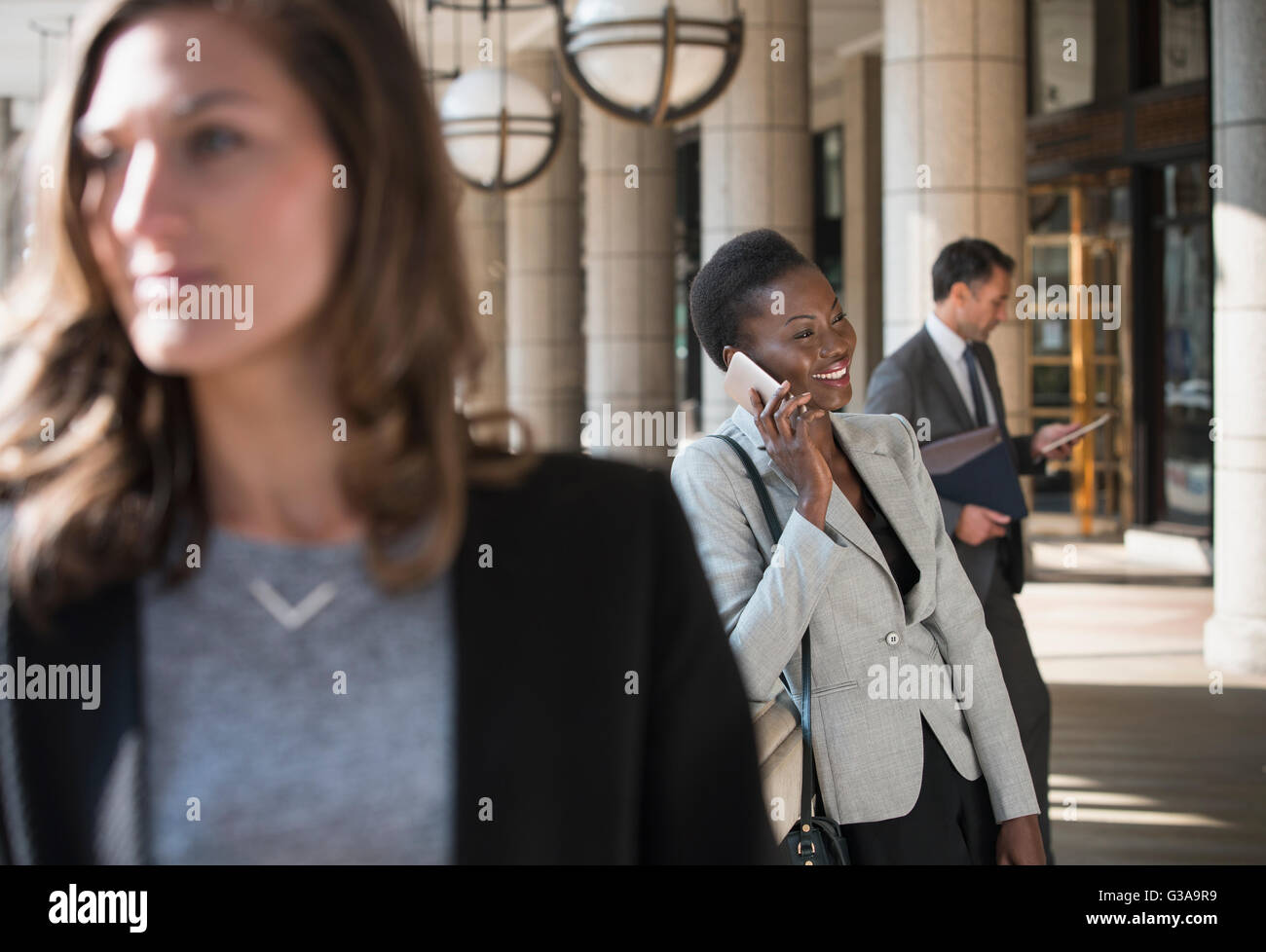 Lächelnde corporate Geschäftsfrau, reden über Handy außerhalb Gebäude Stockfoto