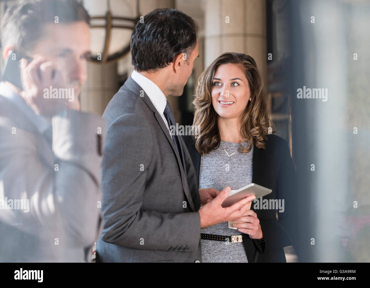 Corporate Geschäftsmann und Geschäftsfrau mit digital-Tablette zu sprechen Stockfoto