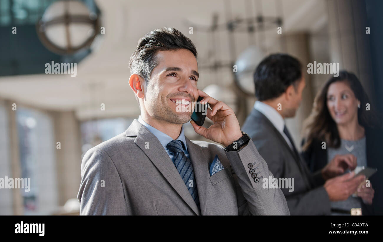 Lächelnde corporate Geschäftsmann reden über Handy Stockfoto