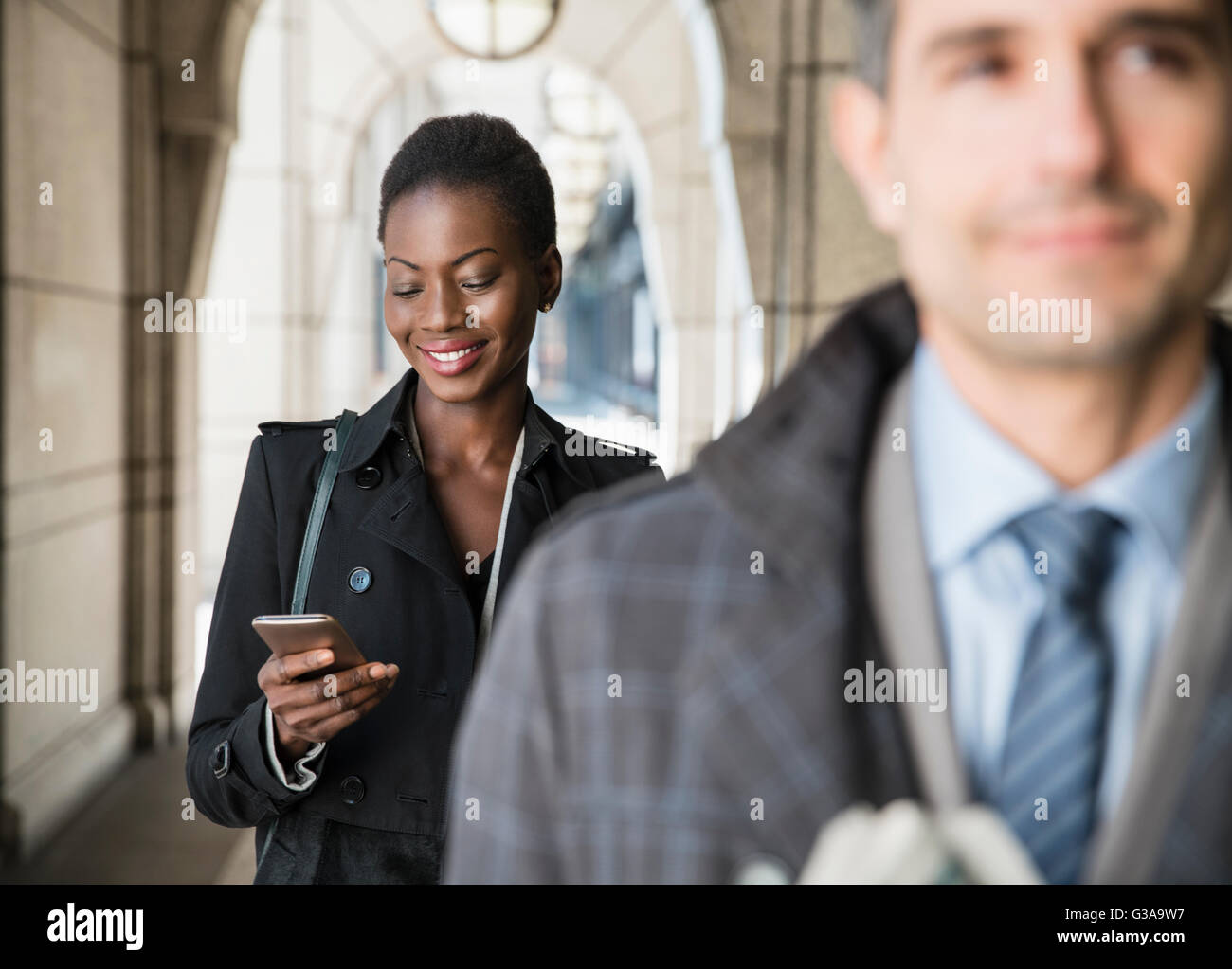 Corporate Geschäftsfrau SMS mit Handy im Kreuzgang Stockfoto