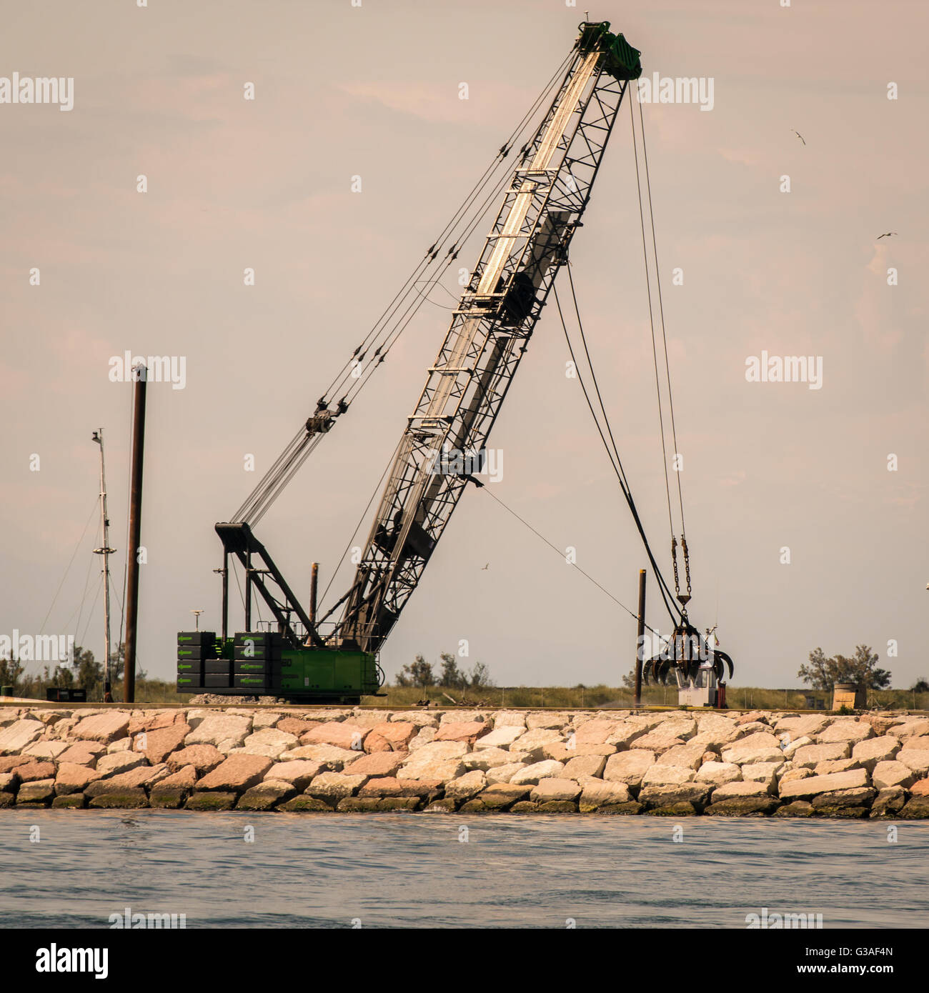 Schnappen Sie sich Kran in Aktion, einen Deich zu bauen. Stockfoto