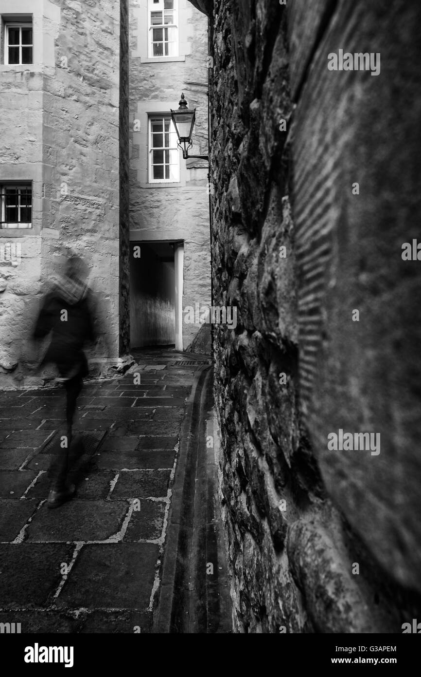 Bewegungsunschärfe als ein Mann geht durch eines der vielen schmalen schließt (Bahn) aus der Royal Mile in Edinburgh, Schottland Stockfoto