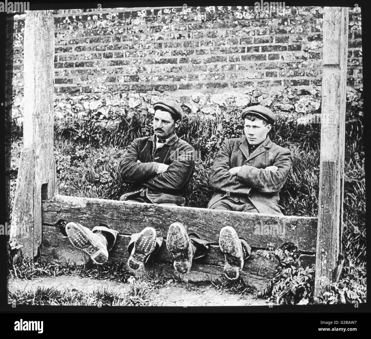 Zwei Kerle in den Beständen suchen sehr satt.         Datum: ca. 1895 Stockfoto