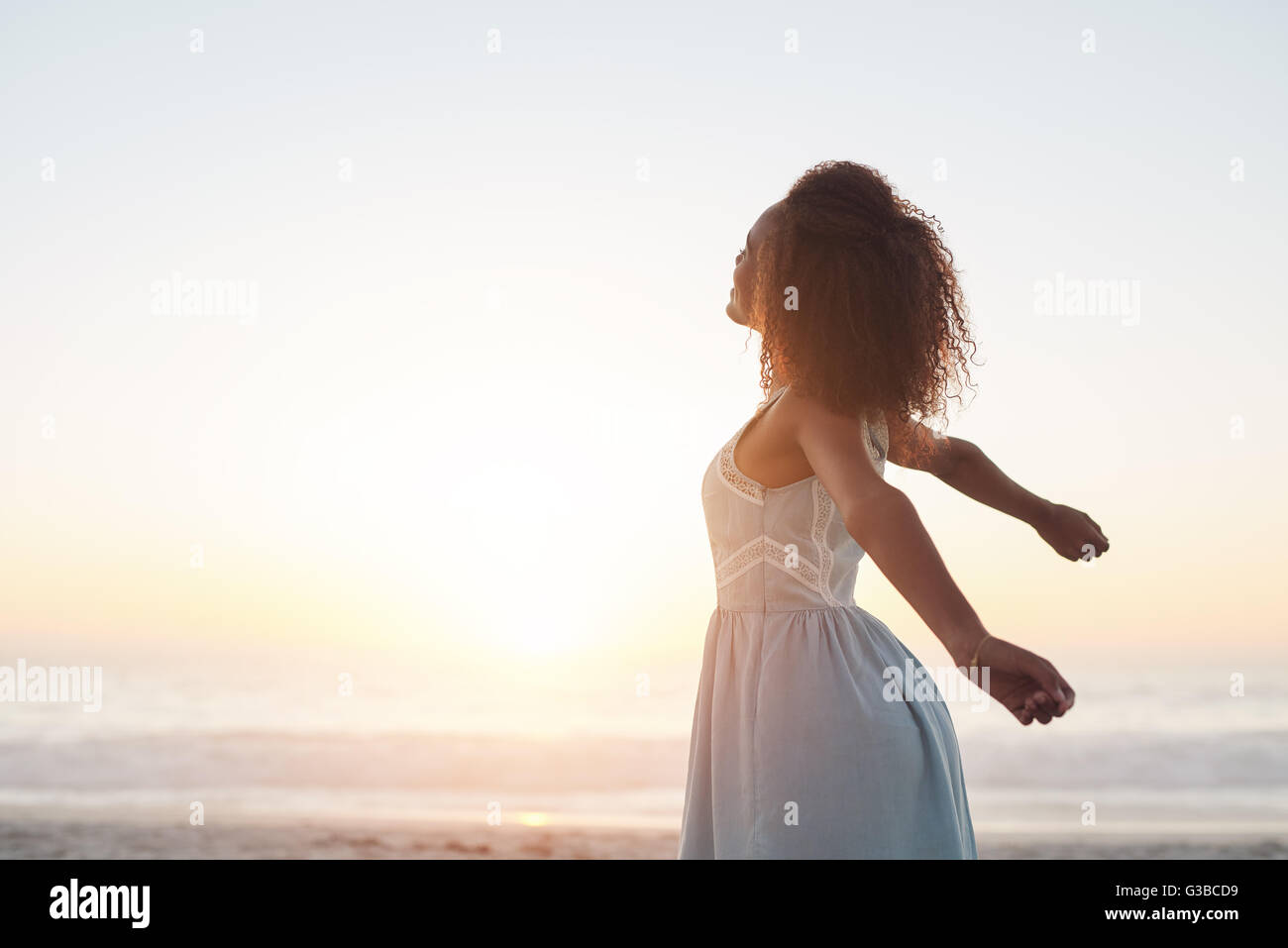 Sie liebt die Freiheit am Strand bei Sonnenuntergang Stockfoto