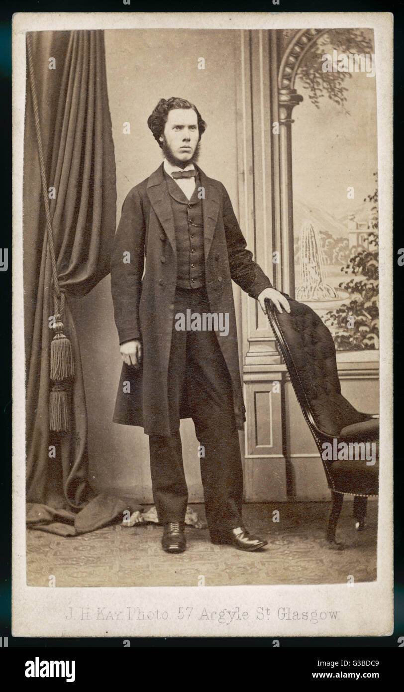 Bärtiger Mann trägt ein Gehrock Weste mit Rollkragen, enge Hosen, schlanke Bowtie &amp; Schnürstiefeln.      Datum: 1860er Jahre Stockfoto