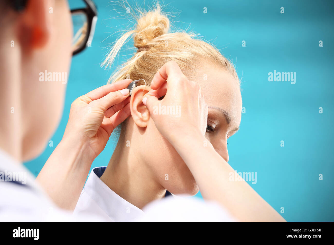 Junge Frau übernimmt ein Hörgerät Stockfoto