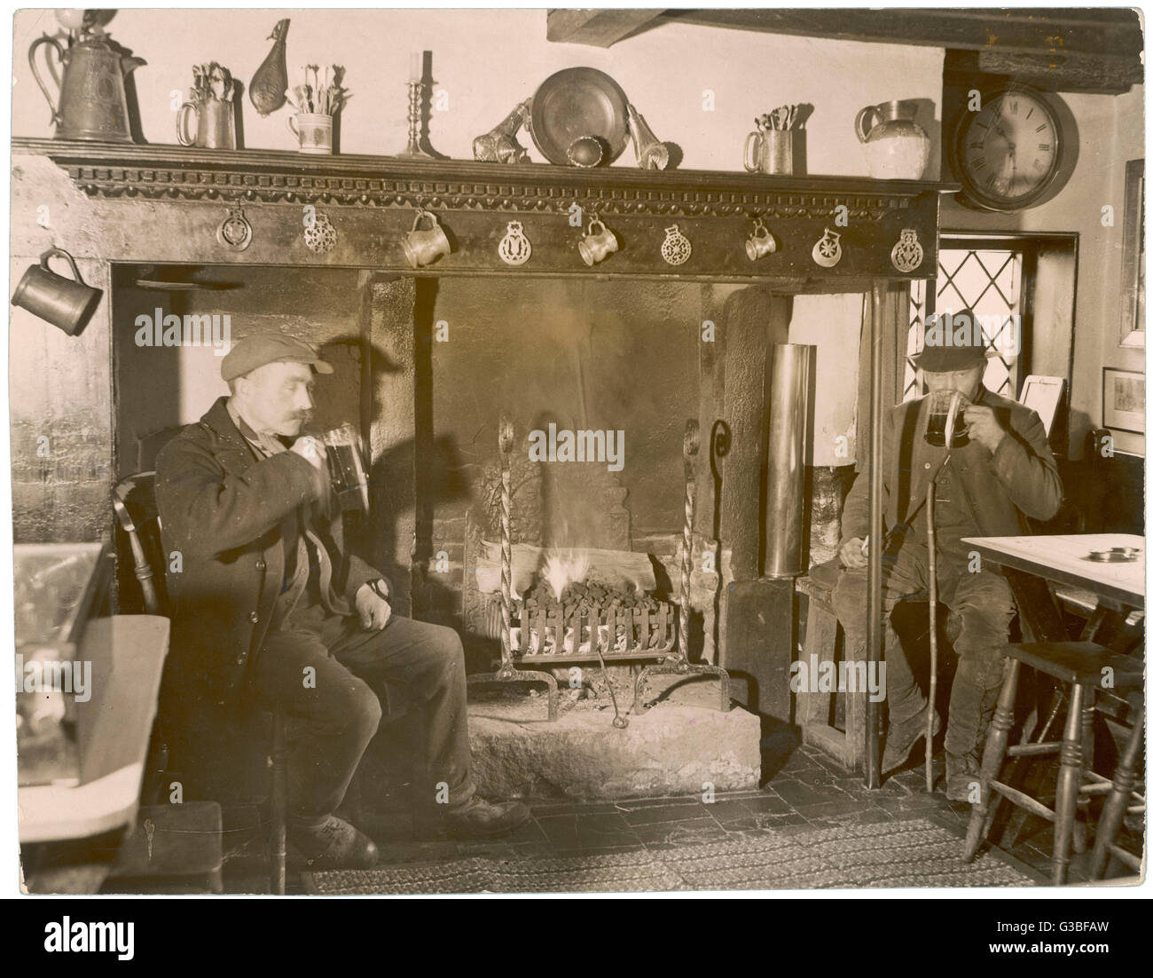 Zwei ländliche Arten sup real Ale aus Bier Krüge neben einem offenen Kamin, umgeben von den Epherema und Dekor typisch für einen klassischen Country-Pub an der alten Pflug in versponnene, Bucks.     Datum: 1935 Stockfoto