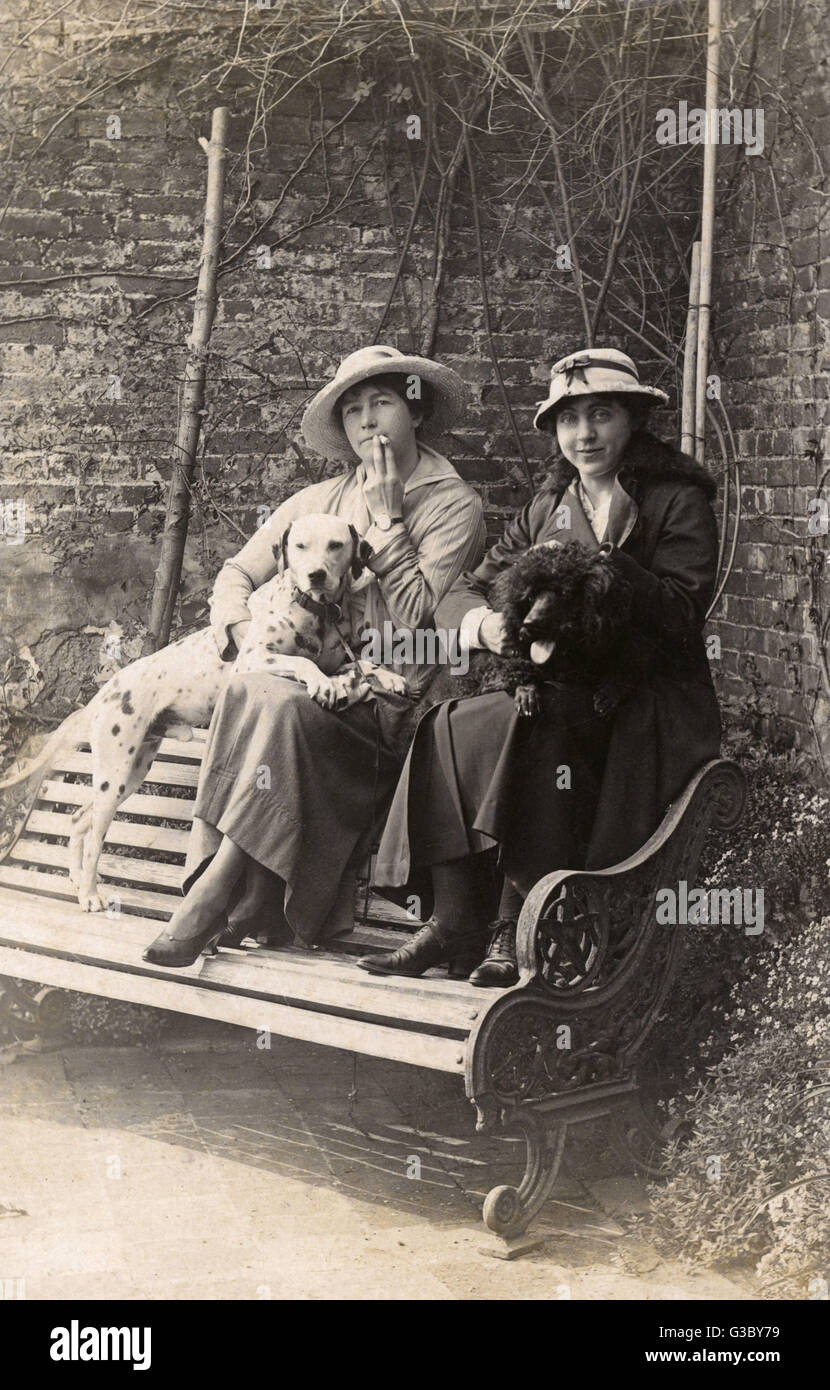 Zwei Frauen und ihre Hunde in einem Garten Stockfoto