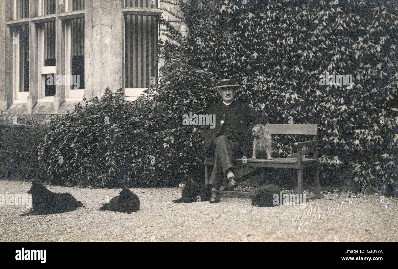 Mann und vier Hunde vor einem großen Haus Stockfoto