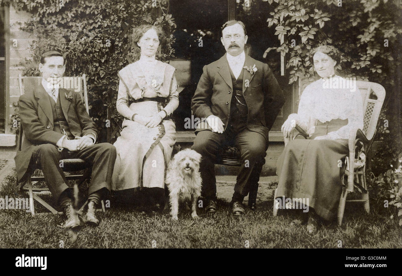 Vier Leute und ein Hund in einem Garten Stockfoto