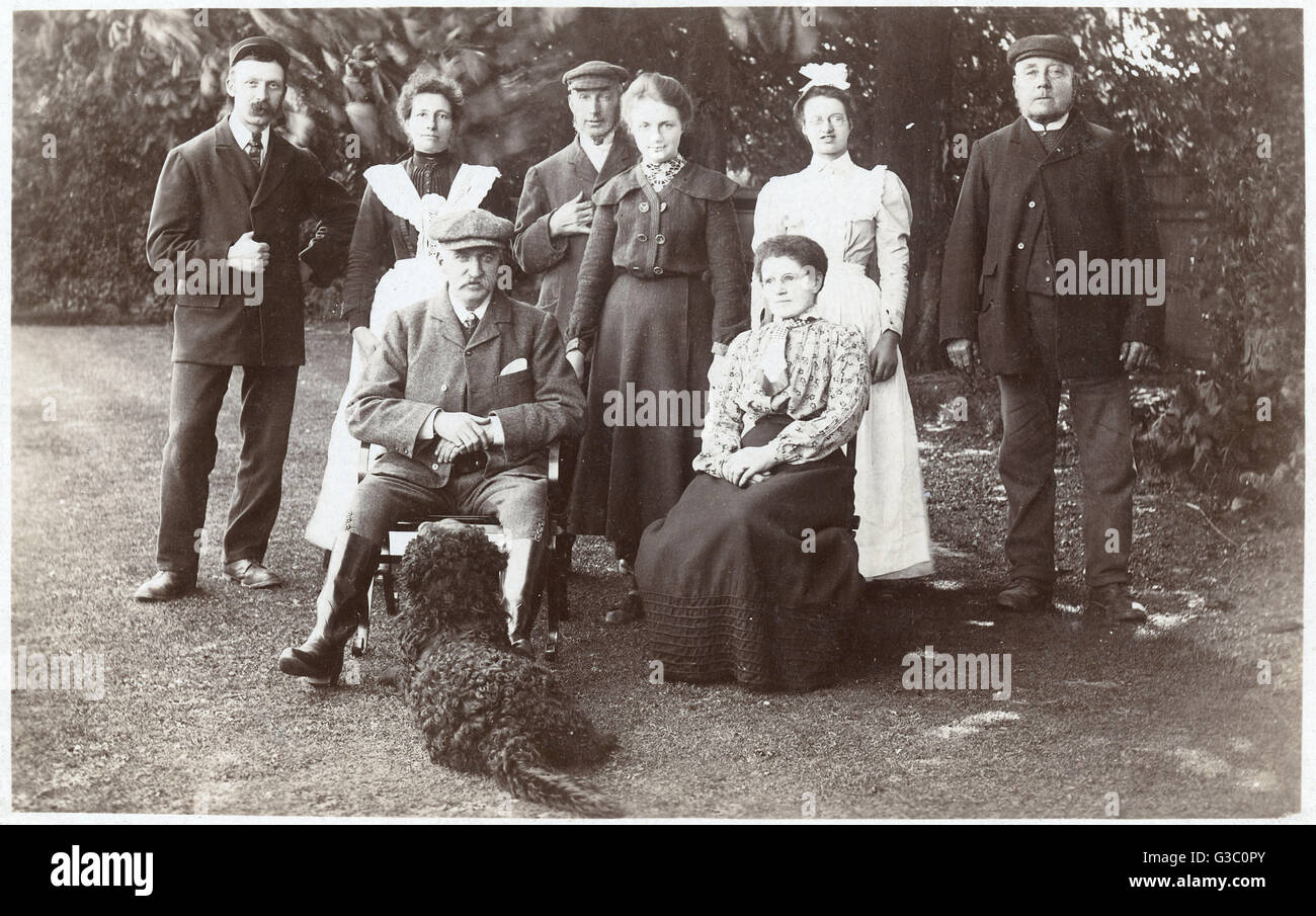 Familiengruppe mit schwarzem Pudel in einem Garten Stockfoto