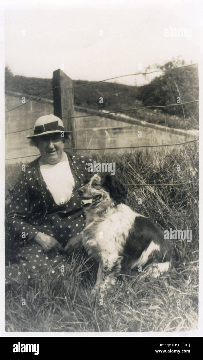 Eine Frau mit einem Hund auf einem Feld Stockfoto