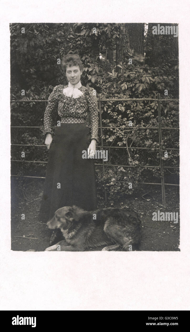 Eine Frau mit einem Hund im Garten Stockfoto