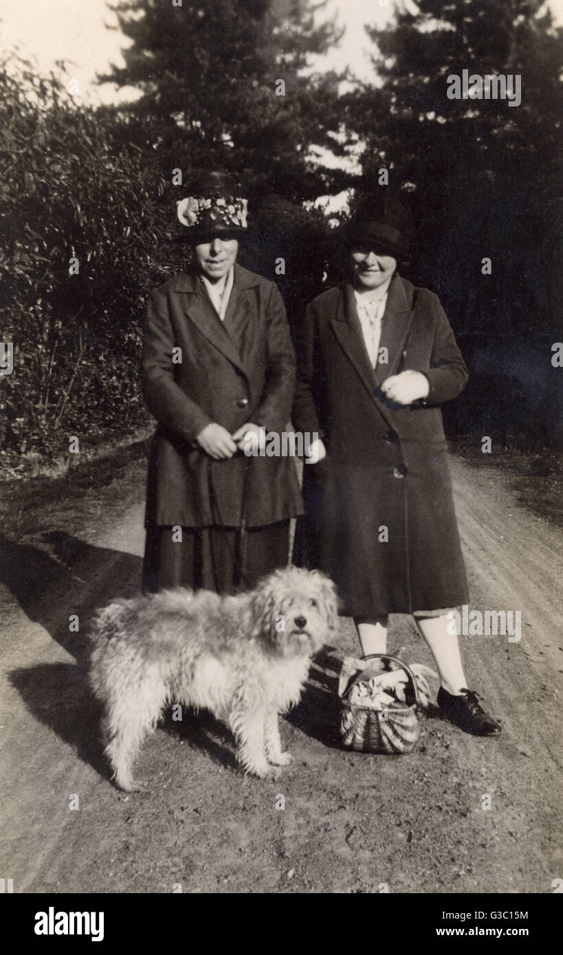 Zwei Frauen mit Hund und Korb auf einer Landstraße Stockfoto