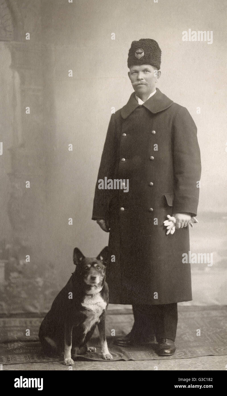 Studioporträt, Uniformierter Mann mit Hund Stockfoto