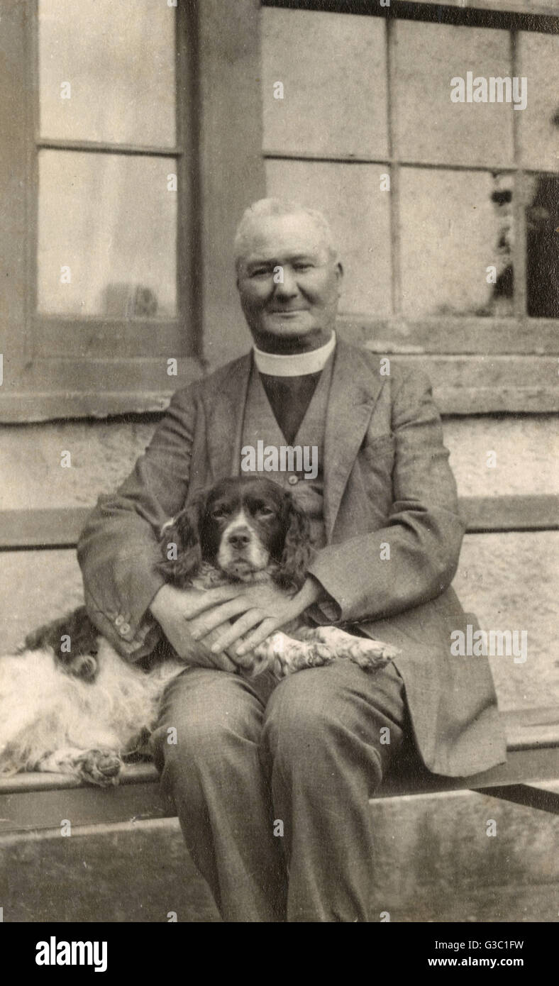 Vikar mit einem Spaniel auf einer Bank Stockfoto