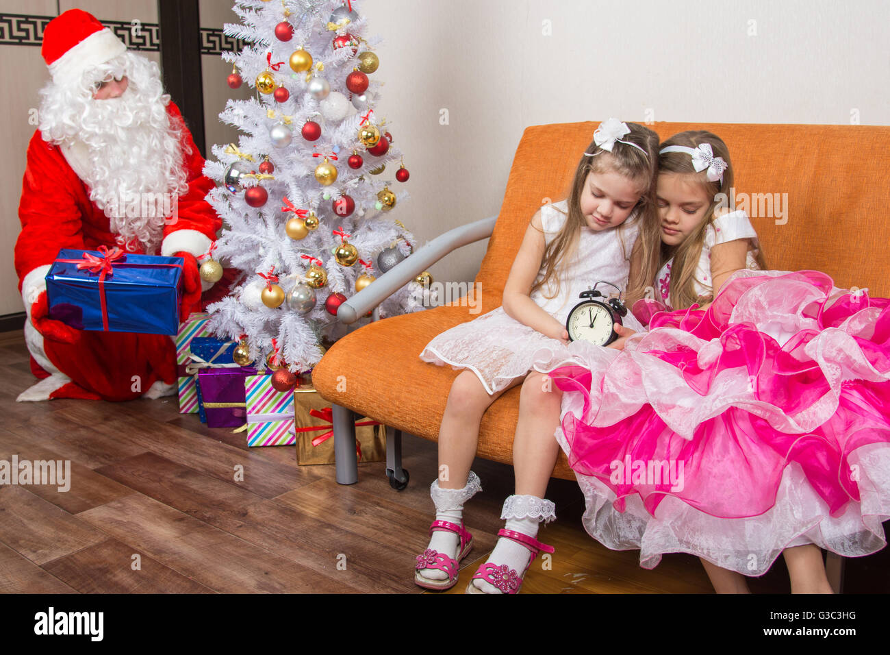 Die Schwestern schlief, während warten auf Santa Claus, Wer ruhig gelegt unter dem Weihnachtsbaum präsentiert Stockfoto
