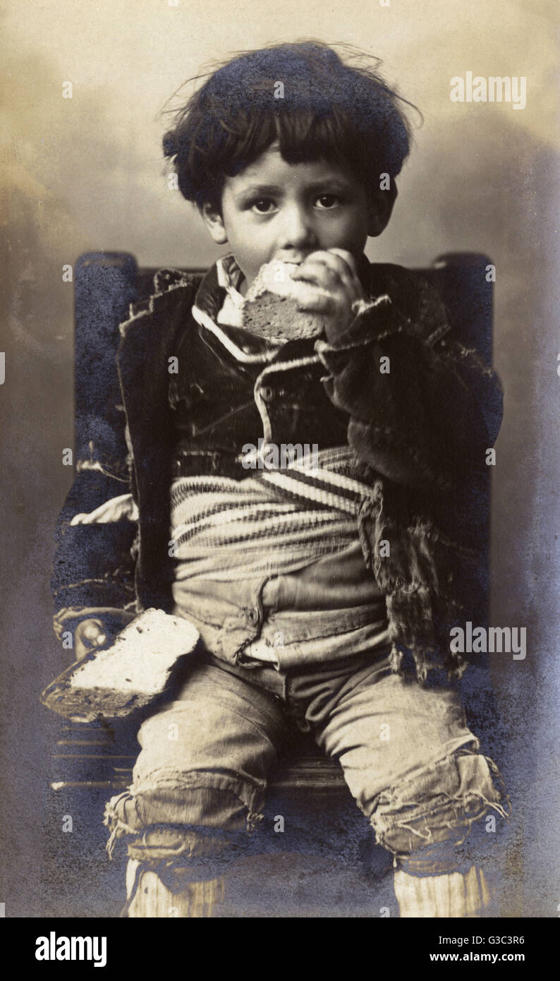 Ein armer Junge, stopfte in ein Stück Brot - Italien.     Datum: ca. 1906 Stockfoto