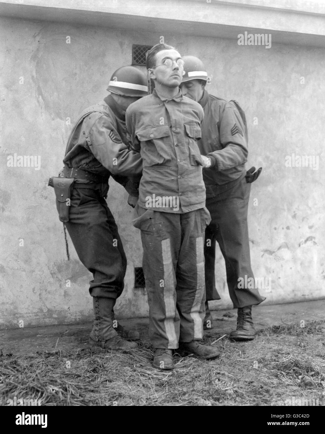 Amerikanische Militärpolizei binden die Hände von Gunther Billing in Vorbereitung auf seine Hinrichtung durch ein Erschießungskommando. Abrechnung und zwei andere hingerichtet am 23. Dezember 1944 wegen Spionage während der deutschen Gegenoffensive in den Ardennen, die als bekannt wurde das Stockfoto
