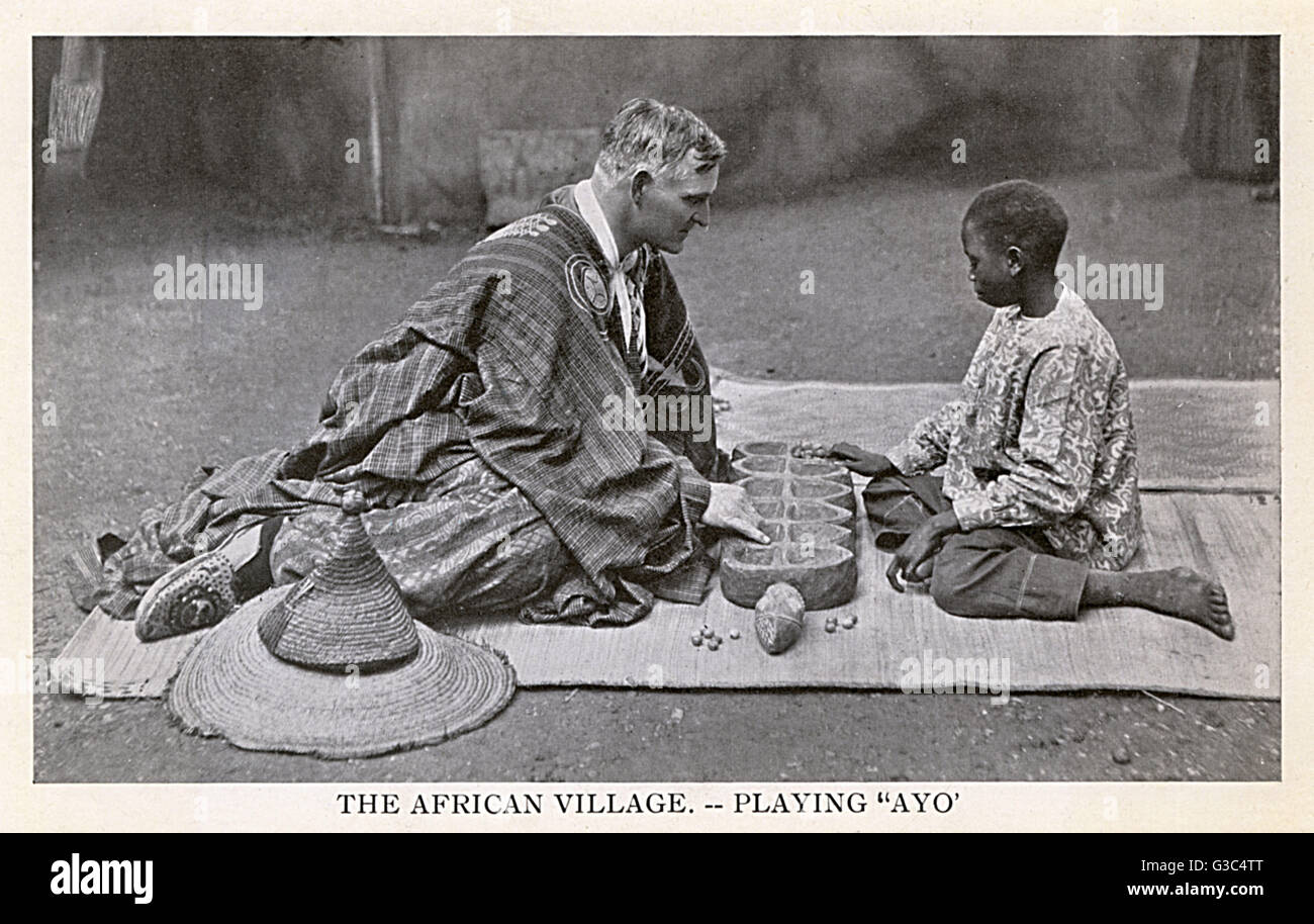 Südafrika - Europäischer Mann und einheimischer Junge spielen ein Ayo-Spiel Stockfoto