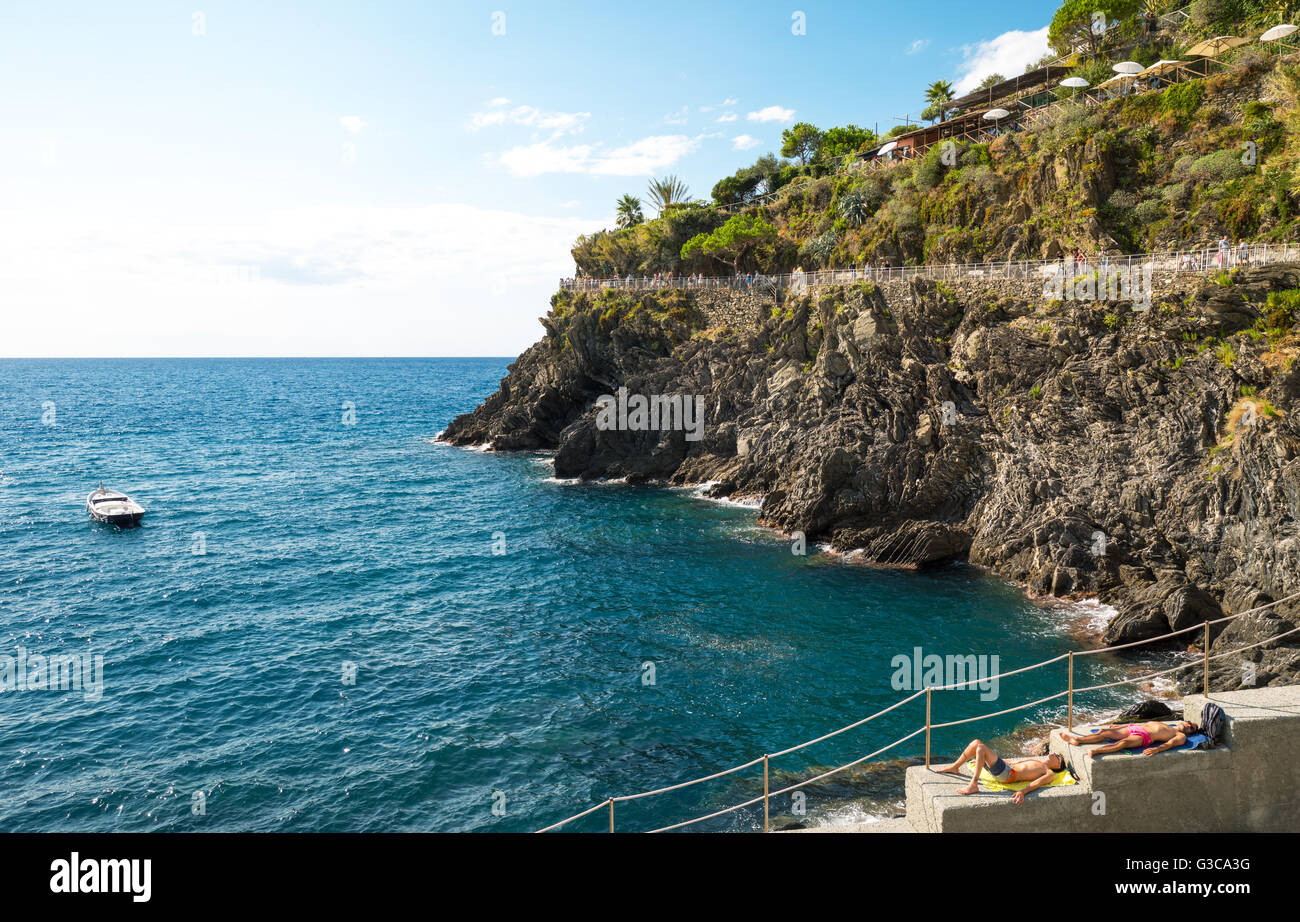 Manarola, Italien - 8. September 2015: The Love Trail nach Riomaggiore mit Sonnenbad von Touristen im Vordergrund. Stockfoto