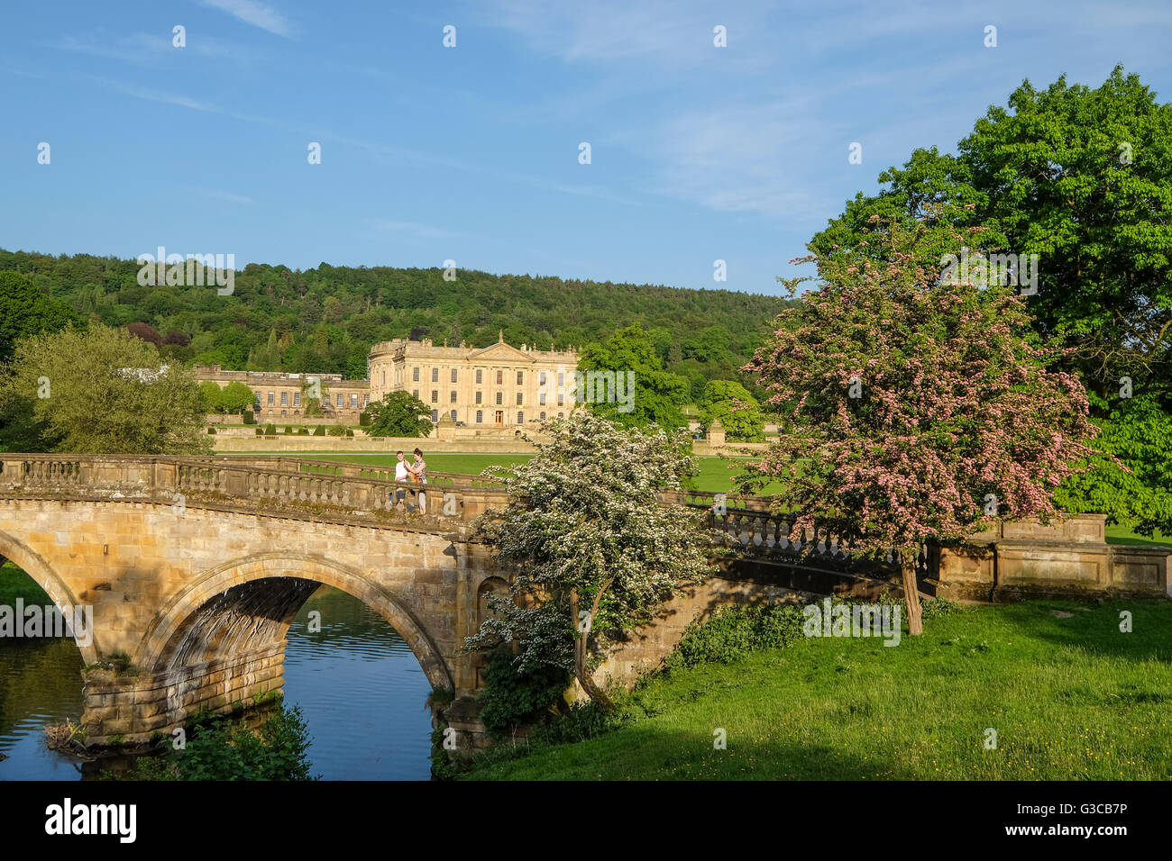 Paar stand auf der Brücke an chatsworth mit dem Haus im Hintergrund Stockfoto