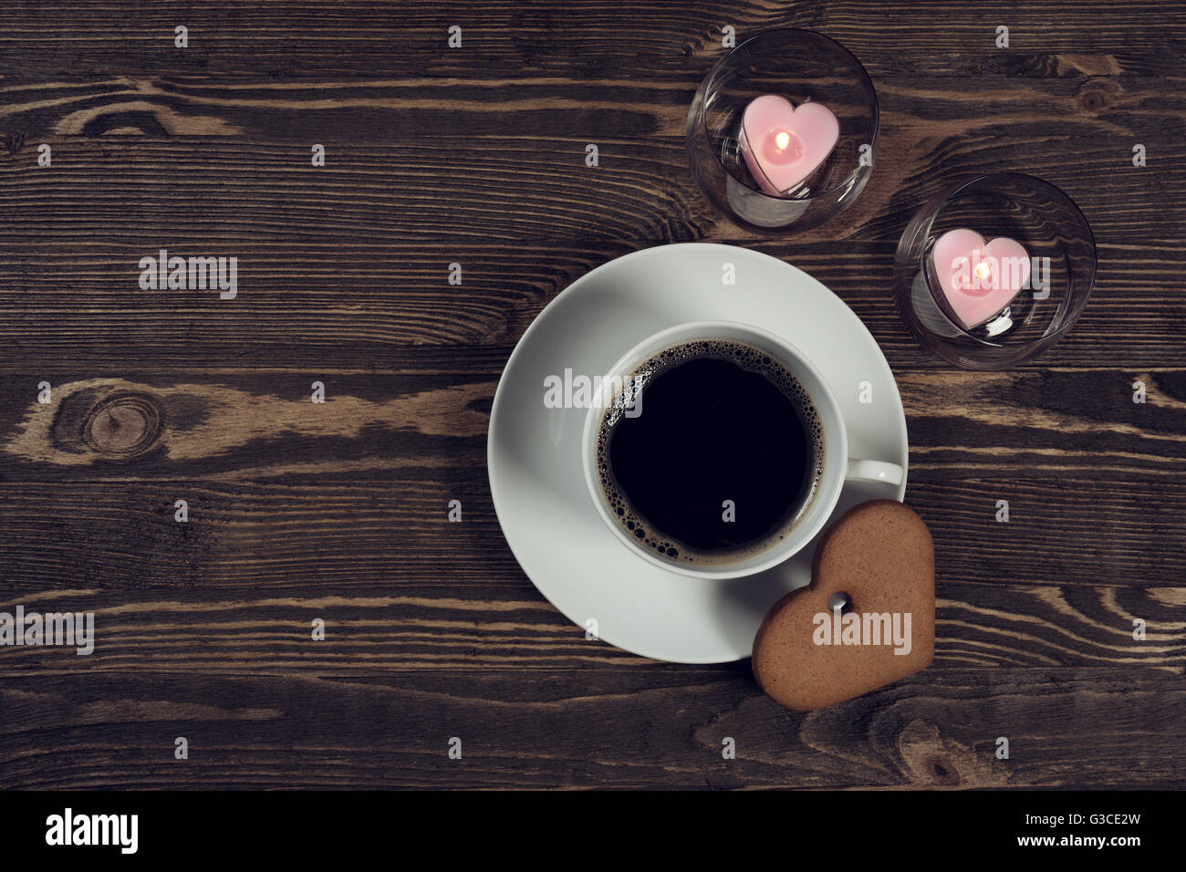 Kaffee und Kuchen in der Form eines Herzens auf Holzbohlen Stockfoto