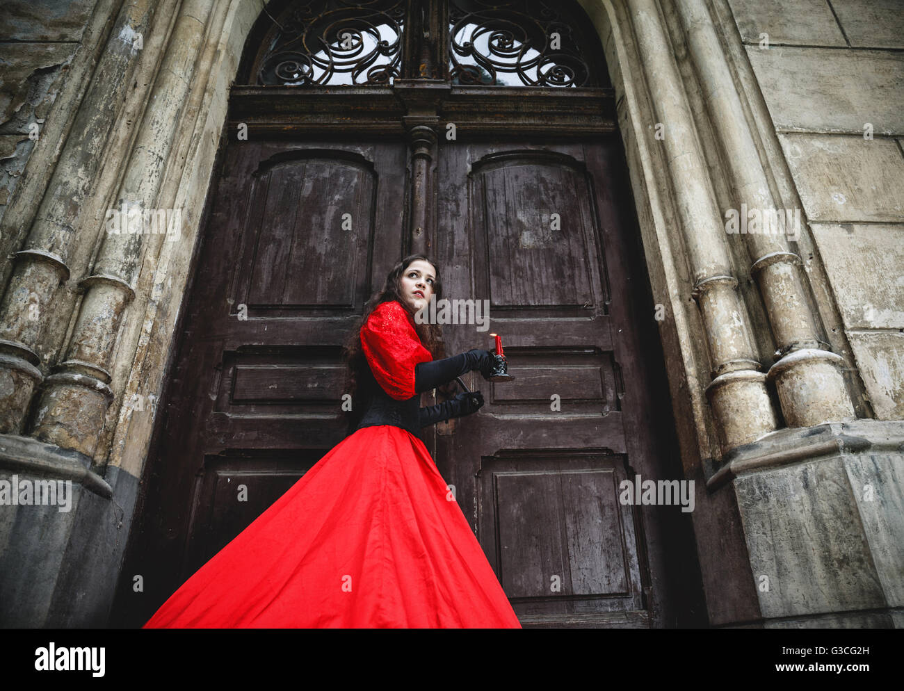Geheimnisvolle Frau in viktorianischen Kleid mit alten Türen Stockfoto