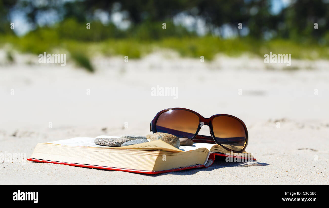 Urlaub zu entspannen. Das Buch und Sonnenbrille am Strand Stockfoto