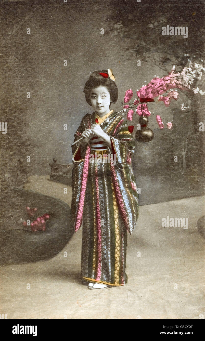 Japan - Junges japanisches Mädchen mit Kirschblüten-Frond Stockfoto