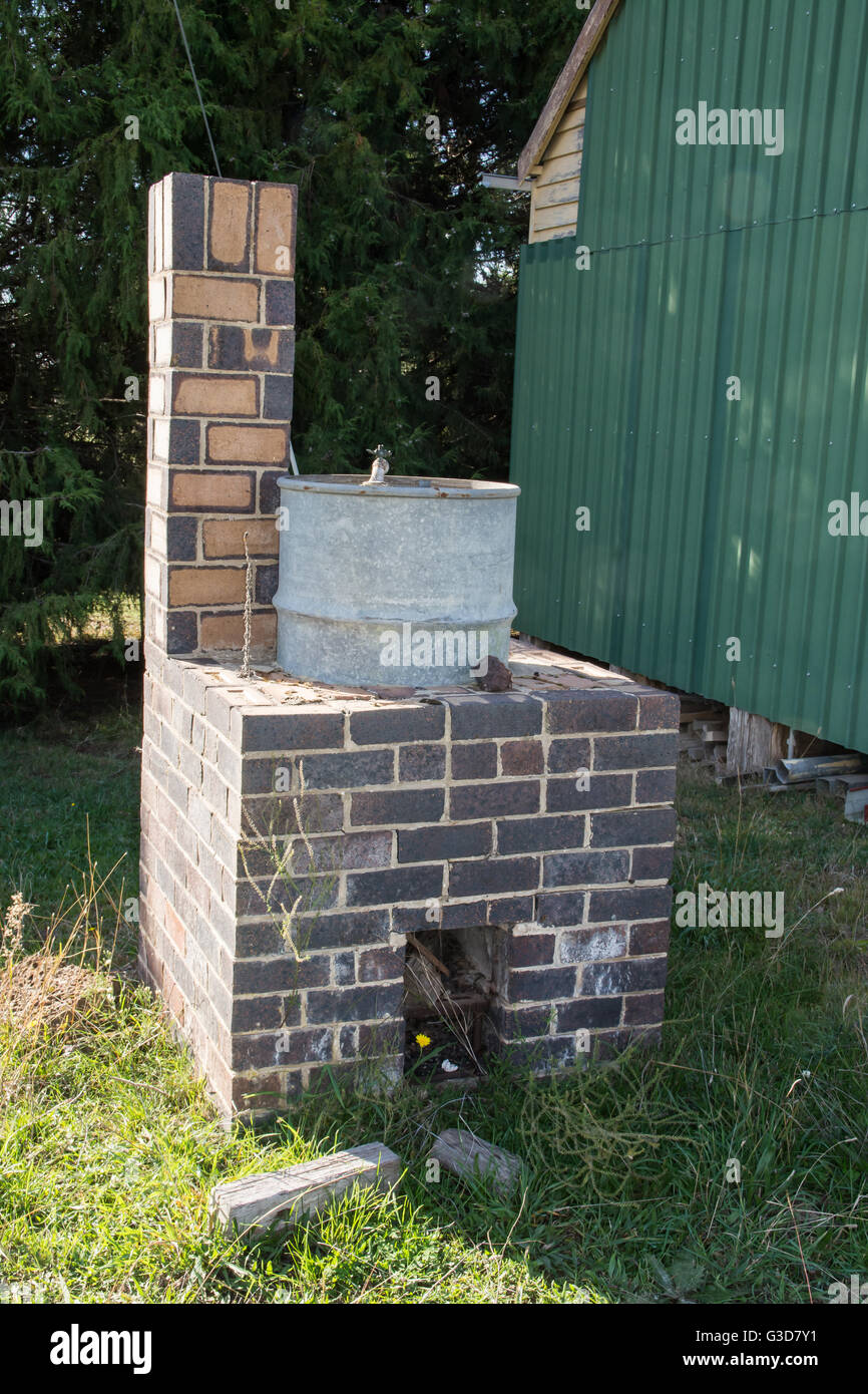 Gemauerten Kamin und 44 Gallone Trommel-Warmwasser-System neben Scheren Shed Stockfoto