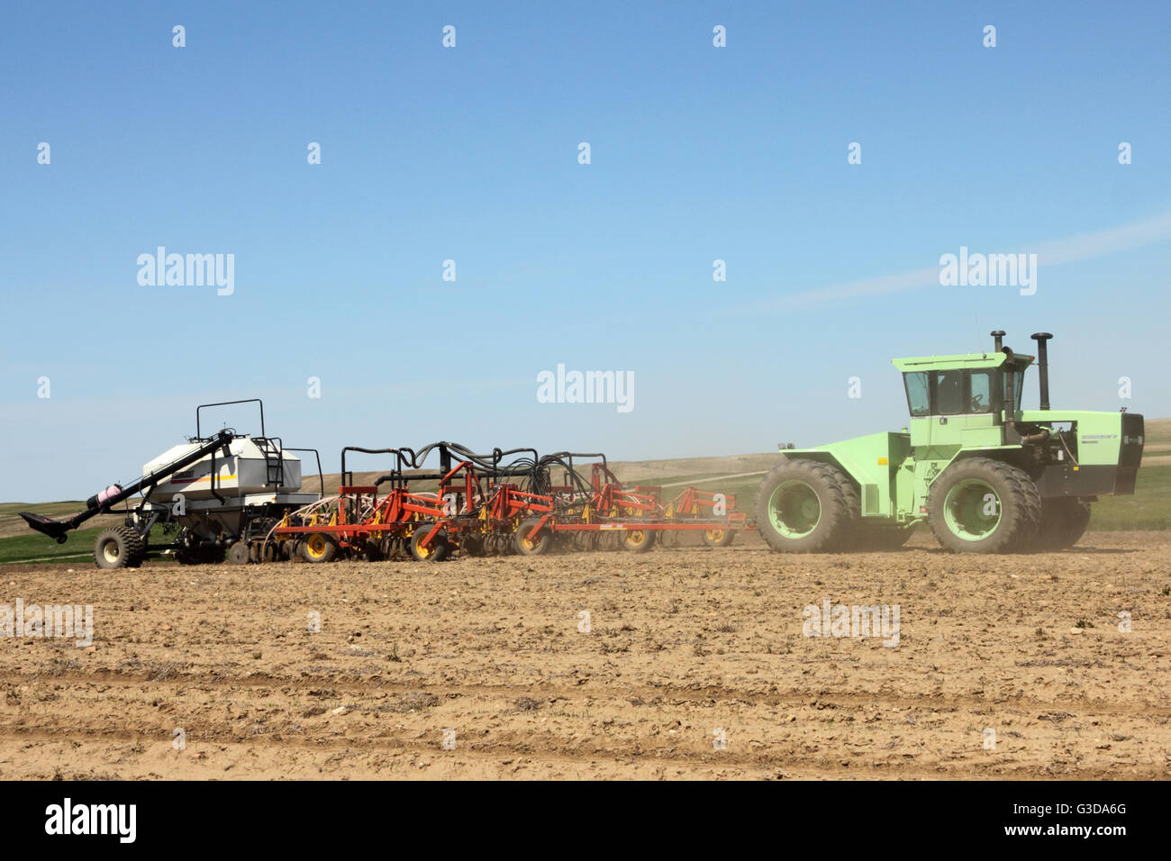 Ein Bauer ein Feld mit einem Steiger Bearcat Traktor ziehen eine Bourgault Luft Hacke Bohrer und Air Seeder Aussaat. In Alberta, Kanada. Stockfoto