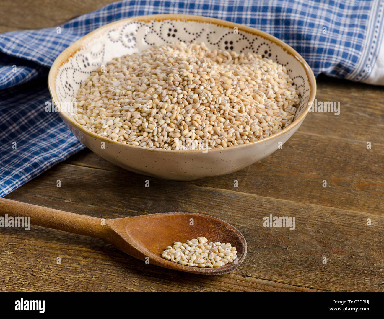 Rohe Gerste in Schüssel auf einem rustikalen Holztisch. Stockfoto