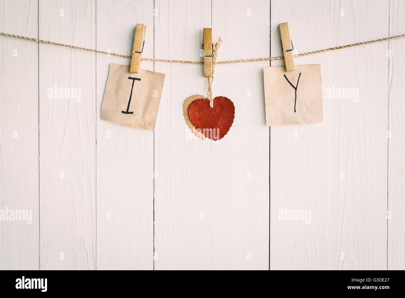 Zwei leere Altpapier und roten Herzen hängen. Auf weißem Holz Hintergrund mit Vintage-Stil. Stockfoto