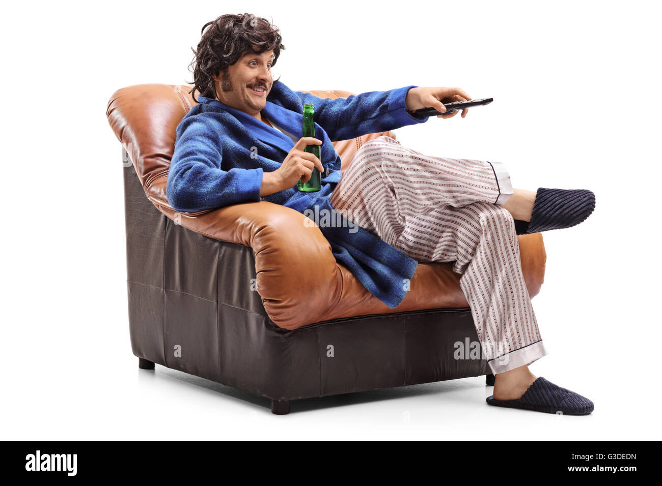 Junger Mann sitzt in einem Sessel mit einem Bier in der Hand und wechseln von Kanälen im Fernsehen isoliert auf weißem Hintergrund Stockfoto